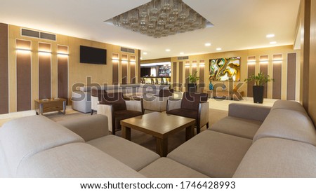 Large corner sofa, table and plants in hotel lounge holl