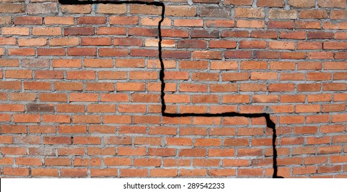 Large crack in a brick wall building foundation                               