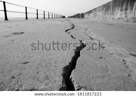 A large crack in concrete. Earthquake concept photo. This picture has selective focus. 