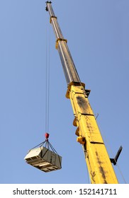 A Large Crane Being Used To Remove A Air Conditioning Unit From A Commercial Building
