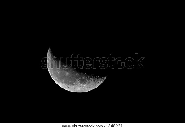 Large crescent\
moon in night sky showing\
craters