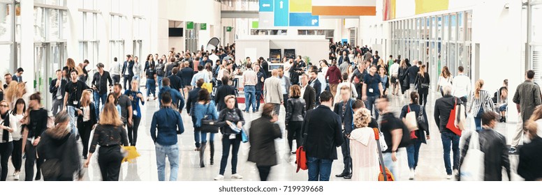 large crowd of anonymous blurred people at a trade fair