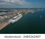 Large cruise ship moored at Southampton UK. Panoramic view of the Southampton city and the docks towards an open sea waters. High altitude aerial on a sunny day.