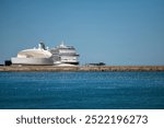 A large cruise ship rests at a contemporary terminal by the serene blue water. Porto. Portugal