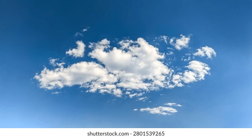 A large cumulus cloud. Clouds flowing lazily like cottony fibers against a clear, serene blue background. The sky speaks of calm, peace, and silence.