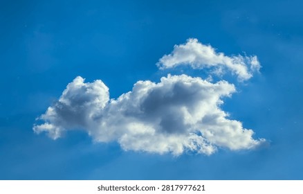A large cumulus cloud. Clouds flowing lazily like cottony fibers against a clear, serene blue background. The sky speaks of calm, peace, and silence.