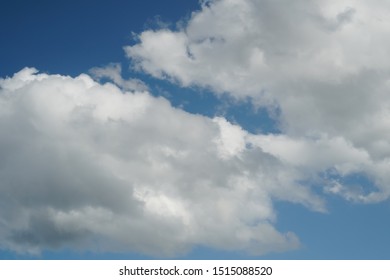 Large Cumulus Clouds On A Bright Blue Sky. The Concept Of Cleanliness And Optimistic Outlook On Problems. Vertical View