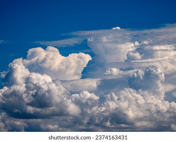 Large cumulus clouds with updrafts, and a few longitudinal clouds in the foreground, at the end of summer in southwest Florida