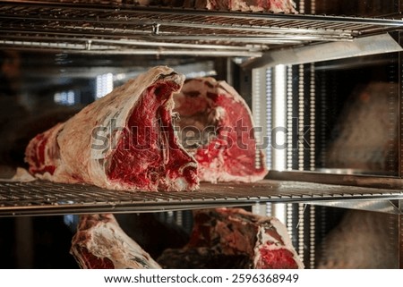 Large cut of raw beef in a dry-aging cabinet.