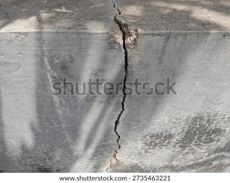 Large and deep cracks on the surface of the concrete wall.