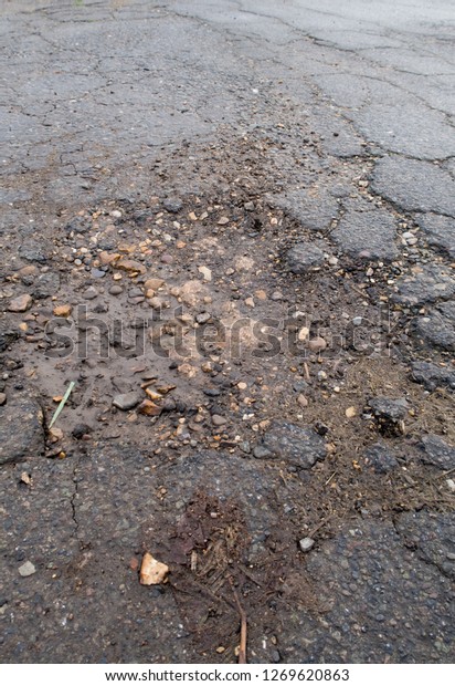 Large deep pot hole in the road. Wisbech Norfolk
UK. wet poor maintenance. Dangerous to traffic. Damage to
vehicles