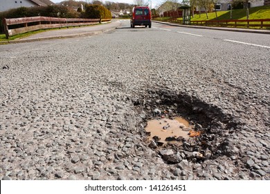 Large Deep Pothole An Example Of Poor Road Maintenance Due To Reducing Local Council Repair Budgets