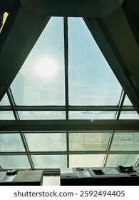 A large diamond-shaped window inside the museum on a sunny day