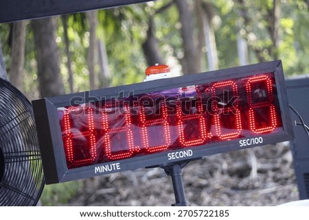 Large digital timer with red display for race countdown. Scoreboard clock shows final second, marking minute for precise time measurement and an exciting finish