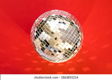 Large disco ball on a red background with highlights and reflection.Festive atmosphere.Copy space 