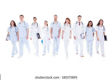 Large Diverse Group Of Doctors And Nurses In Uniform Walking Towards Camera Isolated On White