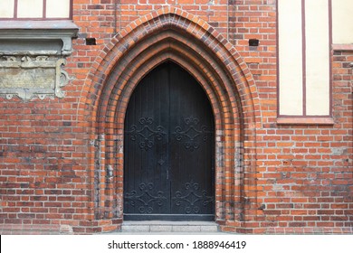 Large double doors in arch of the old castle. Ancient architecture of Europe.