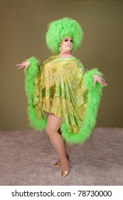 Large Drag Queen In Green Dress And Wig Dances On Rug