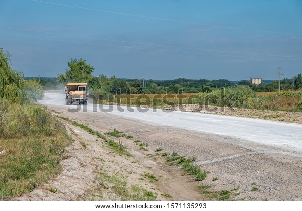large dump truck loaded with rocks drive\
on dust road. Mining industry. Heavy\
equipment.