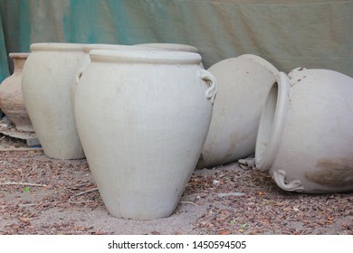 Large earthenware jugs by a wall