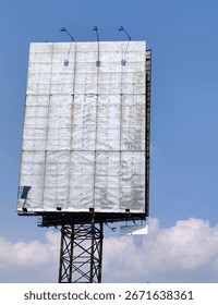 Large empty billboard structure with weathered surface and metal frame against a blue sky