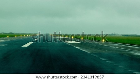 A large, empty and open runway at an airport, ready for takeoffs and landings.