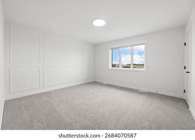 Large, empty room with a window and a light fixture. The room is white and has a clean, minimalist look