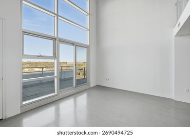 Large, empty room with a large window overlooking a city. The room is clean and empty, with no furniture or decorations. The window lets in a lot of natural light, making the room feel bright