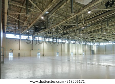 Large empty space in hangar with lights through the windows