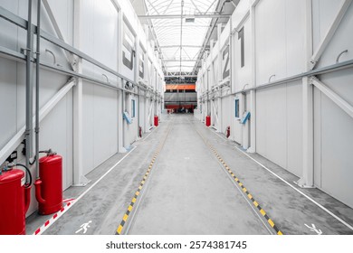 A large, empty warehouse with a white ceiling and red and yellow markings on the floor. The space is numbered 1 through 12