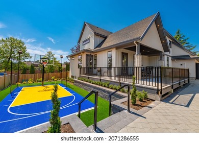Large estate home with sport court backyard sunshine blue sky landscaping and deck