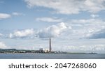 Large factory or plant with tall chimney and industrial harbour on the Northern Ireland coast, Carrickfergus town, County Antrim