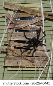 Large Fake Spider And Web On Boarded Window Of House