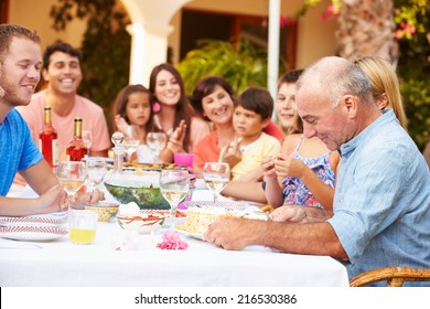 Large Family Group Celebrating Birthday On Terrace Together