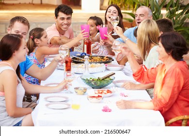 Large Family Group Enjoying Meal On Terrace Together