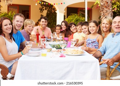 Large Family Group Enjoying Meal On Terrace Together