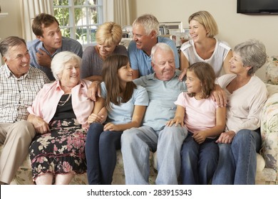 Large Family Group Sitting On Sofa Indoors