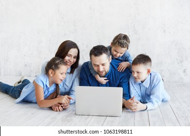 A Large Family Is Looking At The Laptop. Happy Big Family At Home By Computer