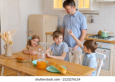 Large Family With Teenage Children Eating Breakfast In Kitchen. Caucasian Parents And Children Decided To Have Snack And Drink Fresh Juice At Home In Kitchen. Happy Caucasian Kids And Mom With Dad