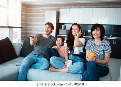 A Large Family Is Watching TV. Brothers, Sisters, Mother, Grandmother And Baby Granddaughter