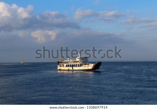 Large ferryboat carrying passengers and cars\
crossing in blue sea between Bali island and East Java, Indonesian\
cargo logistics transportation delivery concept Boat on sea.\
Transportation. Shipping.