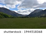 Large field in a valley between two mountain ranges.