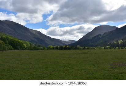 Large field in a valley between two mountain ranges.