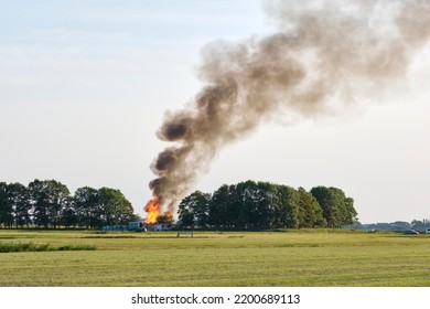 Large Fire On The Horizon Of An Agricultural Field With A Huge Pillar Of Smoke In De Sky. Fire Near Hallum Friesland In The Netherlands