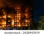 A large fire in a residential building in the city of Valencia, Spain, which quickly burns to the ground. View of the facade with a large column of smoke.