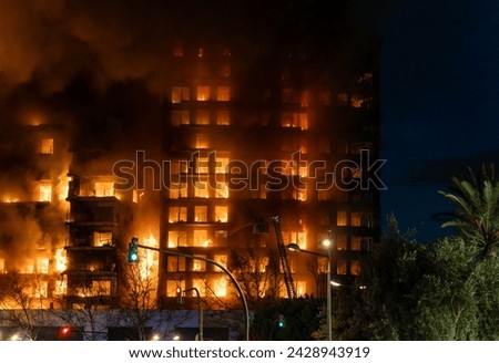 A large fire in a residential building in the city of Valencia, Spain, which quickly burns to the ground. View of the facade with a large column of smoke.