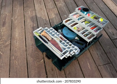A large fishermans tackle box fully stocked with lures and gear for fishing.