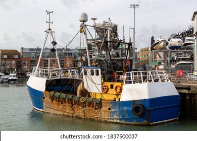 A Large Fishing Trawler Docked At A Quay