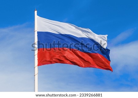 Large flag of the Russian Federation on a flagpole 75 meters high. Technological device with wind speed sensors and automatic flag height adjustment system. Blagoveshchensk, Far East, Russia. Close up