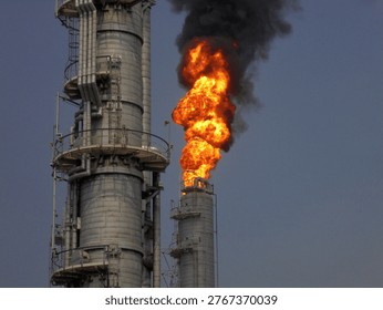 Large Flare Stack Burning With Massive Flame And Black Smoke At Refinery